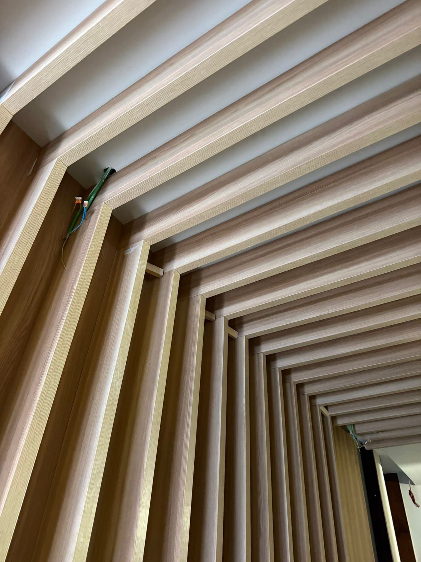 Curved slat ceiling with integrated lighting
