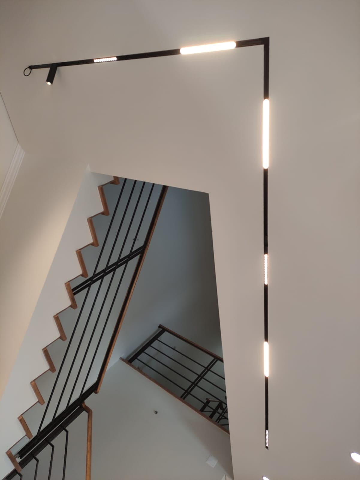 Linha de luz contínua a acompanhar a escada, de piso a piso
