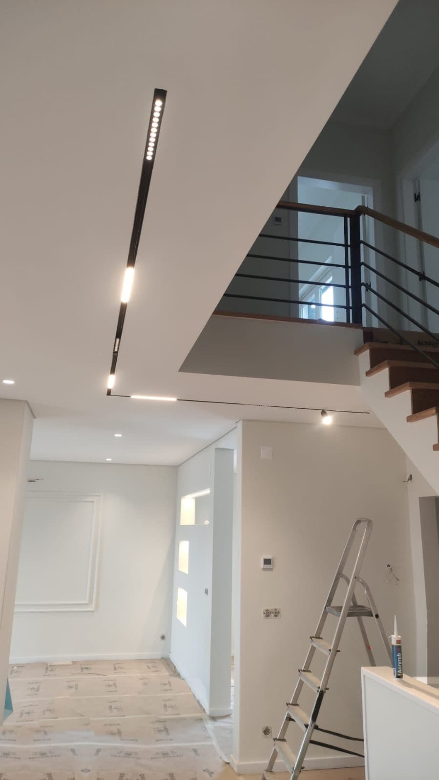 Calha com focos lineares na sala, junto à escada